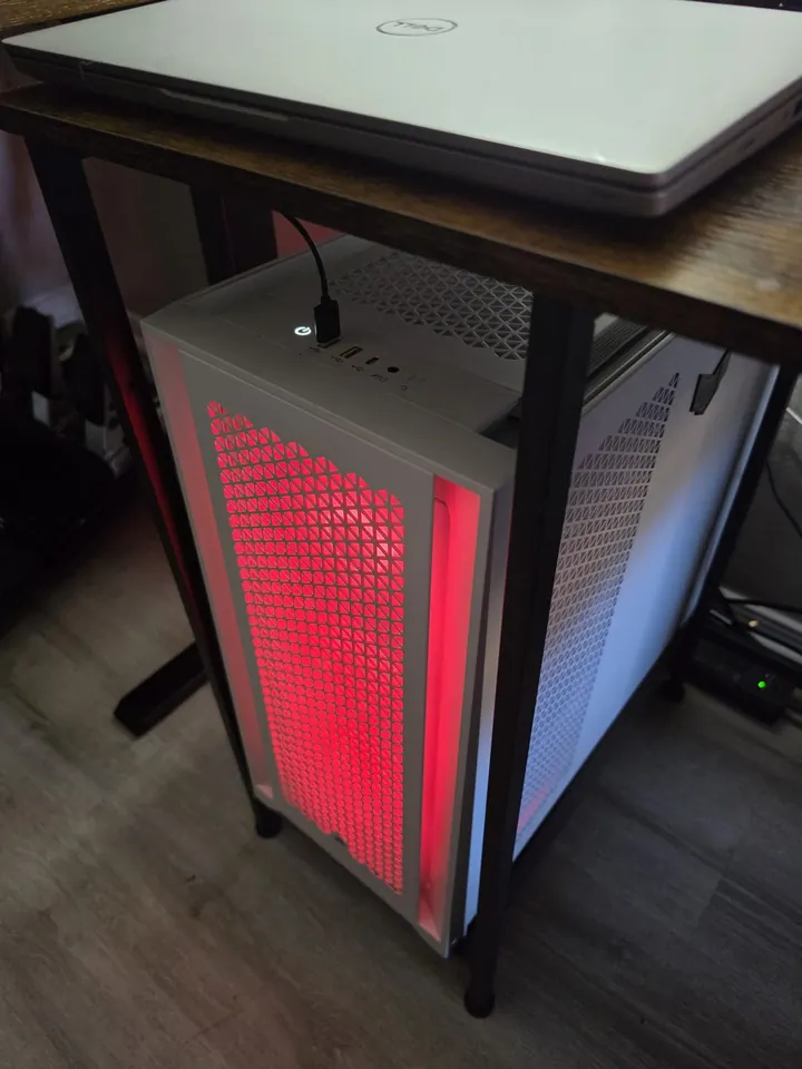 The white Frostbyte desktop under a desk, with red light showing through the front grille.